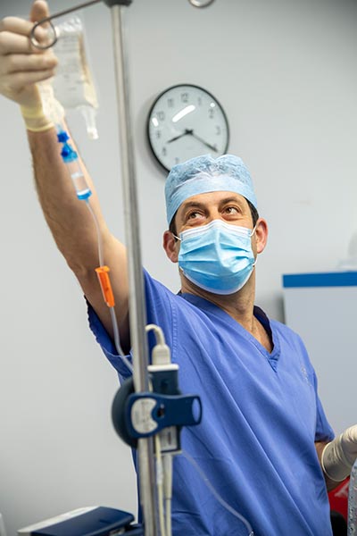 Surgeon adjusting patients drip
