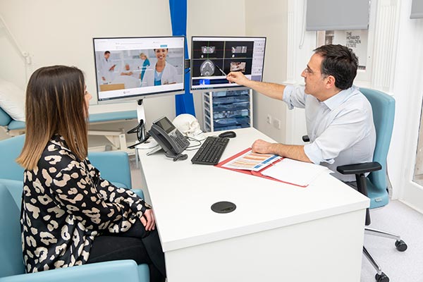 Consultant oral surgeon with patient at a desk showing her xray