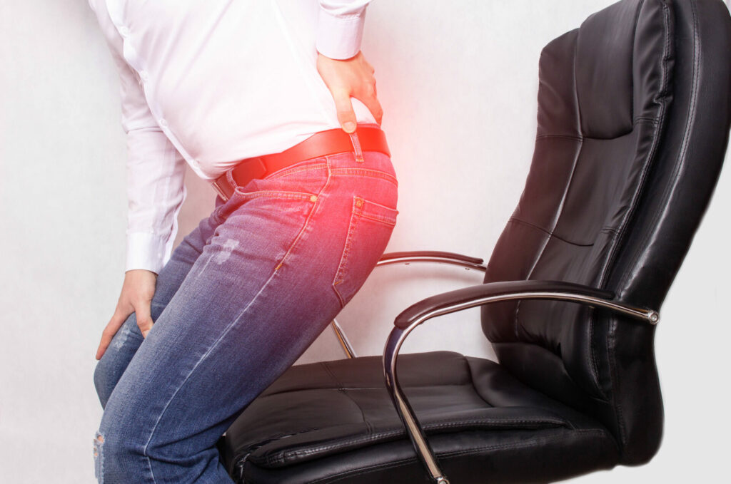 man getting up from his office chair with back pain