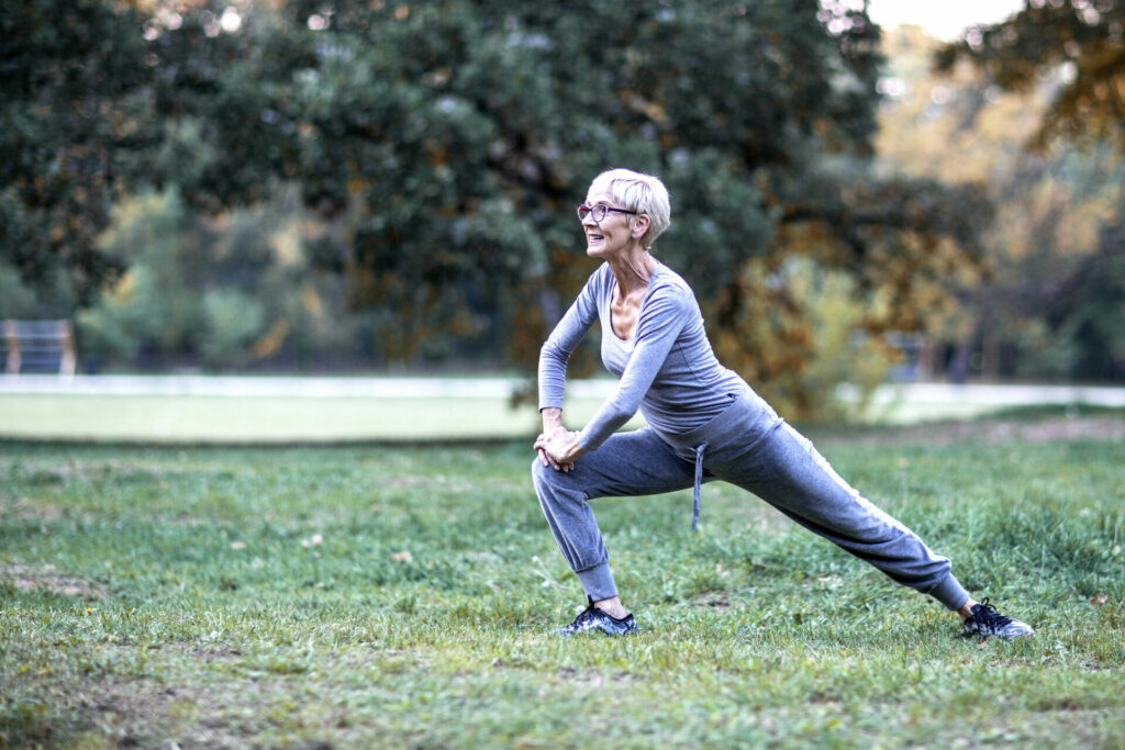 older woman stretching at an outdoor park