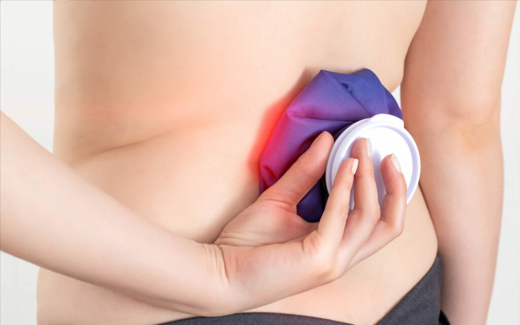 person applying ice pack to their lower back