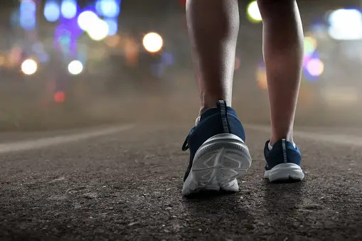 person in running shoes on the road