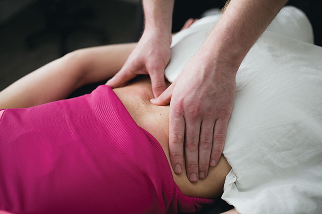 person massaging another person's lower back