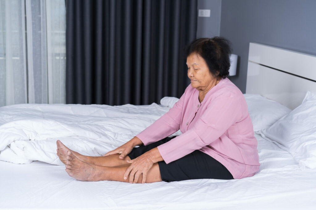 older woman with leg pain in bed