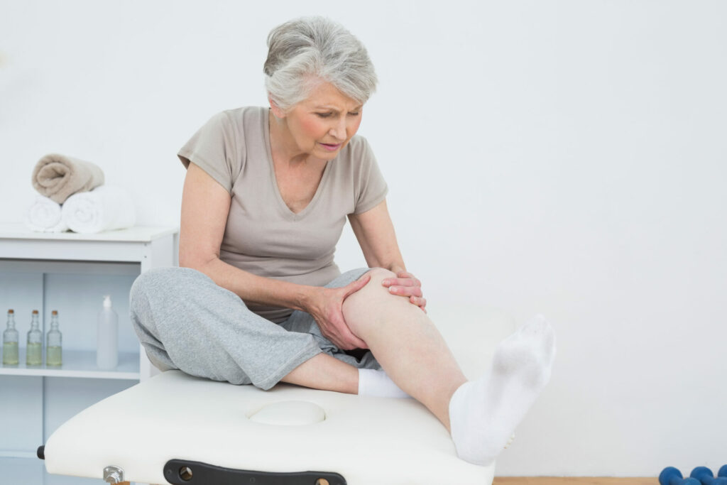 older woman clutching her knee in pain