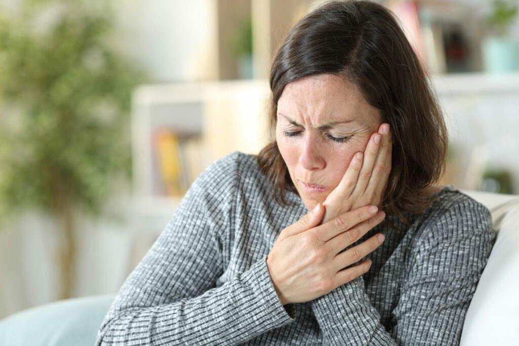 woman sitting at home with jaw pain